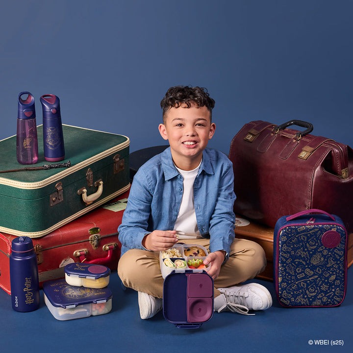 Child holding an open Harry Potter mini lunch box with other b.box accessories