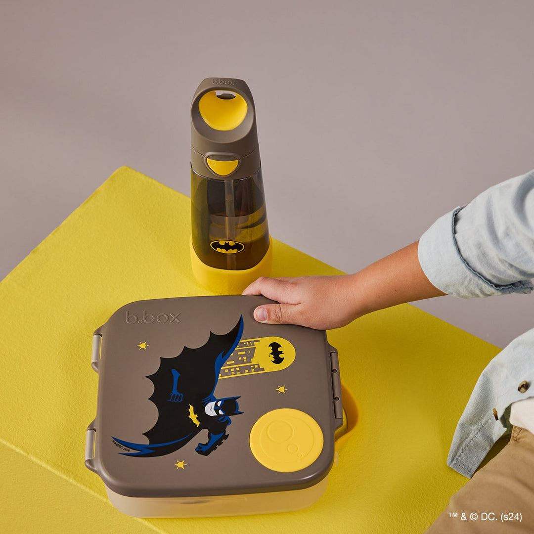 B.Box Batman lunch box on a yellow table beside a matching drink bottle, sold separately