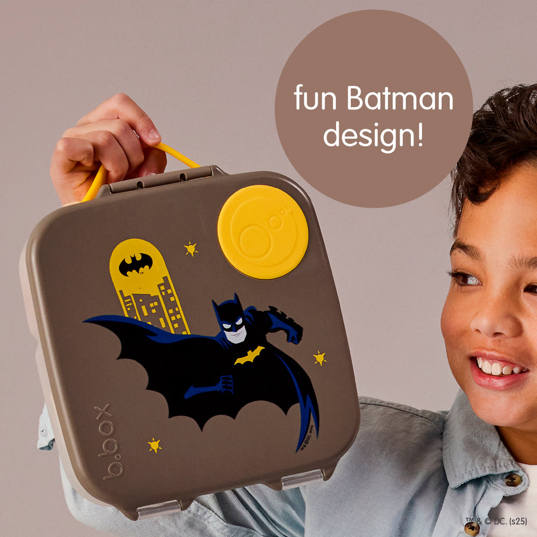 Child holding B.Box Batman lunch box by its yellow carry handle